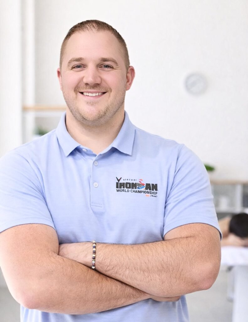 Dr. Jarren Miller, licensed chiropractor and owner of Apex Chiropractic and Sports Rehab in Preston, Idaho, smiling in professional clinic setting.