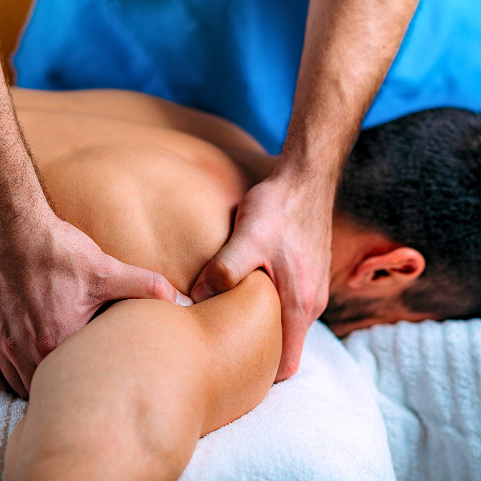 Licensed therapist performing deep tissue massage on a patient’s shoulder to relieve muscle tension and improve mobility.