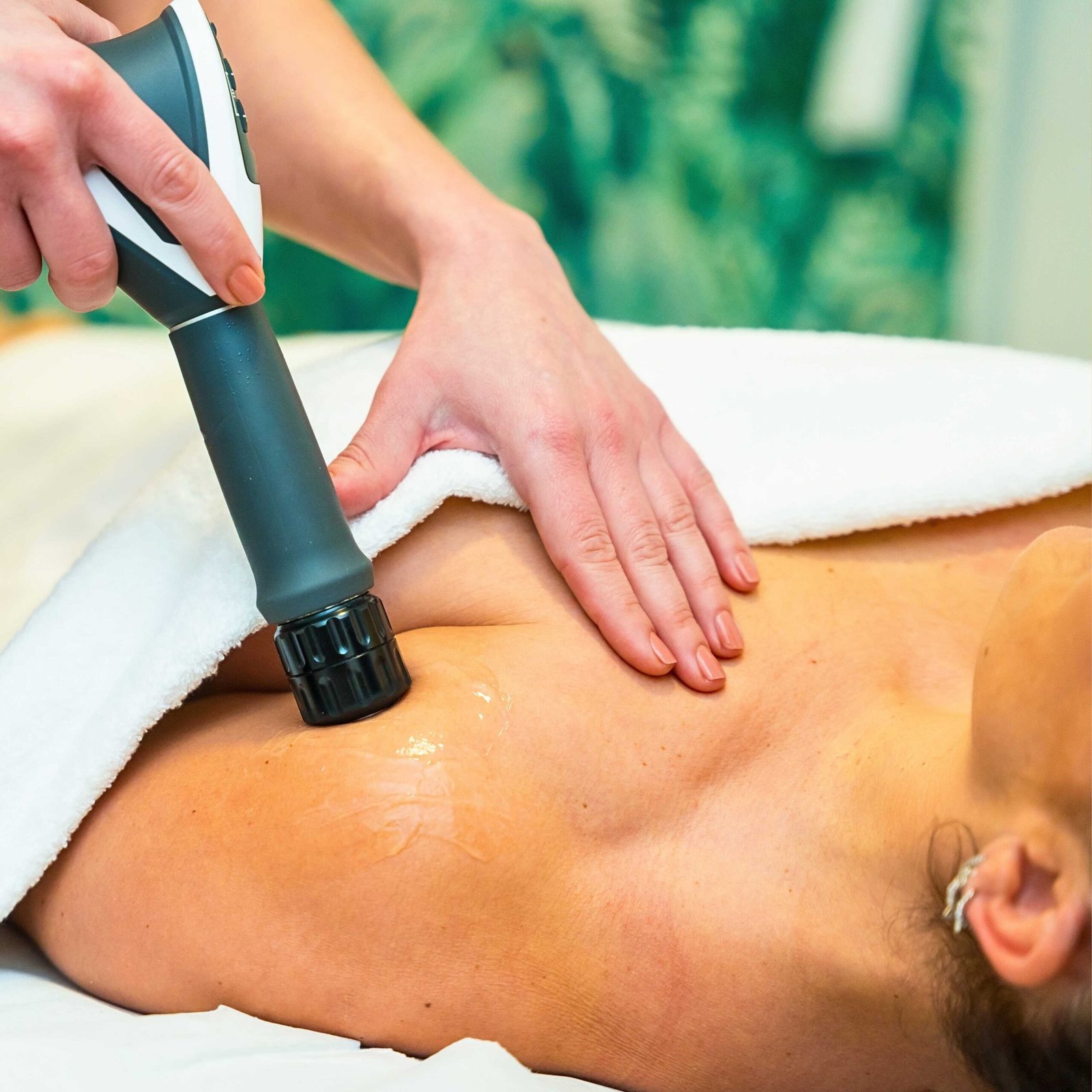 Shockwave therapy being applied to a patient’s shoulder using a non-invasive handheld device to promote healing and reduce pain.